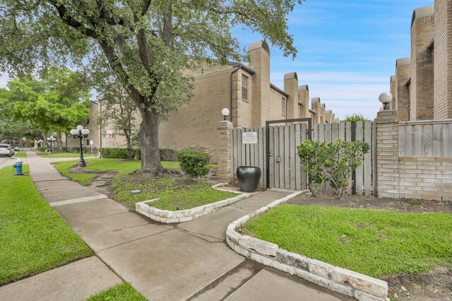 9850 Pagewood Ln Unit 1208, Houston, TX 77042 - view of property exterior with a gate and brick siding