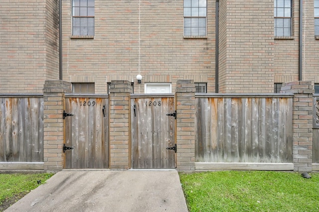 9850 Pagewood Ln Unit 1208, Houston, TX 77042 - view of exterior entry featuring a gate, brick siding, and fence