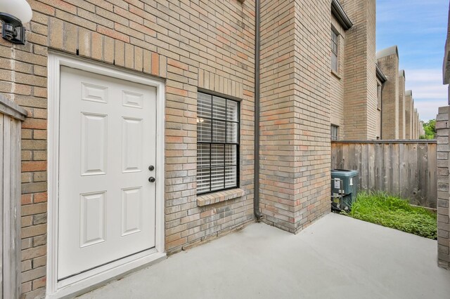 9850 Pagewood Ln Unit 1208, Houston, TX 77042 - property entrance featuring fence, a patio area, central air condition unit, and brick siding