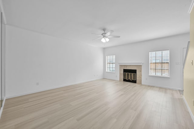 9850 Pagewood Ln Unit 1208, Houston, TX 77042 - unfurnished living room with ceiling fan, light wood-style floors, a tile fireplace, and baseboards