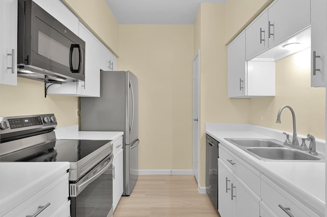 9850 Pagewood Ln Unit 1208, Houston, TX 77042 - kitchen with stainless steel appliances, a sink, light countertops, white cabinets, and light wood finished floors