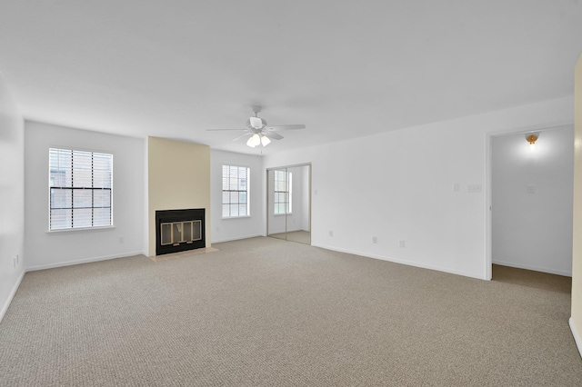 9850 Pagewood Ln Unit 1208, Houston, TX 77042 - unfurnished living room featuring a fireplace with flush hearth, light colored carpet, ceiling fan, and baseboards