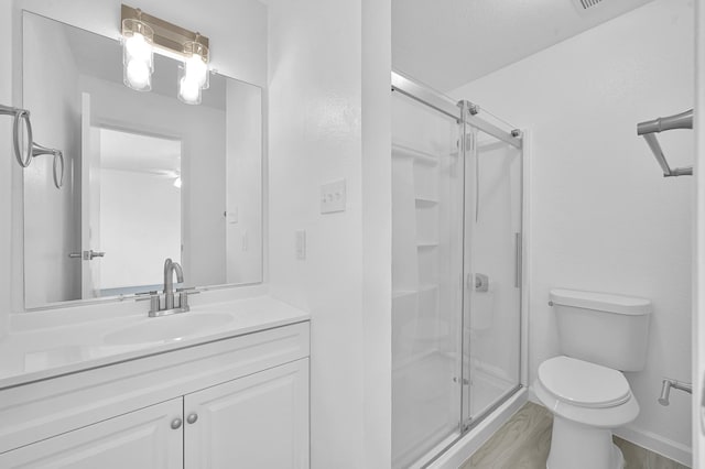 9850 Pagewood Ln Unit 1208, Houston, TX 77042 - bathroom featuring toilet, a stall shower, vanity, and wood finished floors