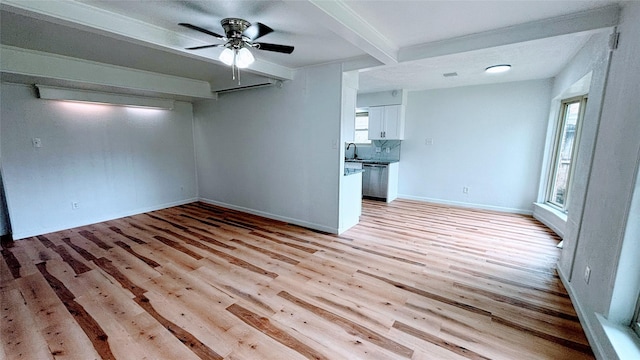 14406 Roundstone Ln, Houston, TX 77015 - unfurnished living room featuring a ceiling fan, beamed ceiling, light wood-style floors, and baseboards