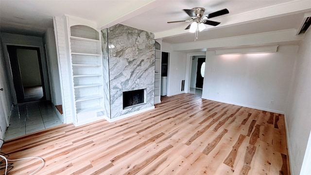 14406 Roundstone Ln, Houston, TX 77015 - unfurnished living room with a high end fireplace, wood finished floors, a ceiling fan, and baseboards