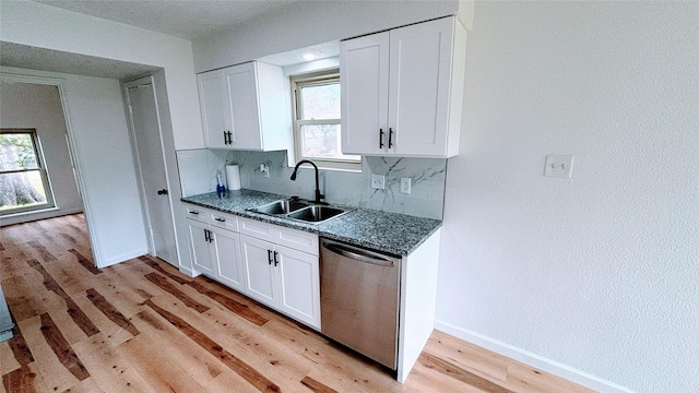 14406 Roundstone Ln, Houston, TX 77015 - kitchen with stainless steel dishwasher, a sink, light wood finished floors, and white cabinetry