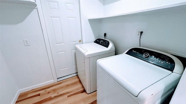 14406 Roundstone Ln, Houston, TX 77015 - washroom with light wood-type flooring, washer and dryer, and baseboards