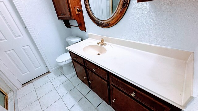14406 Roundstone Ln, Houston, TX 77015 - bathroom featuring toilet, vanity, a textured wall, and tile patterned flooring