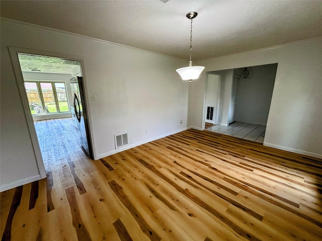 14406 Roundstone Ln, Houston, TX 77015 - unfurnished dining area with light wood-style flooring, ornamental molding, and baseboards