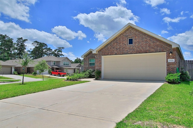 view of front facade featuring brick siding, a front yard, driveway, and a garage