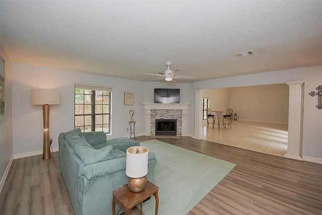 2030 Cutter Dr, League City, TX 77573 - living area featuring wood finished floors, ceiling fan, a stone fireplace, and baseboards