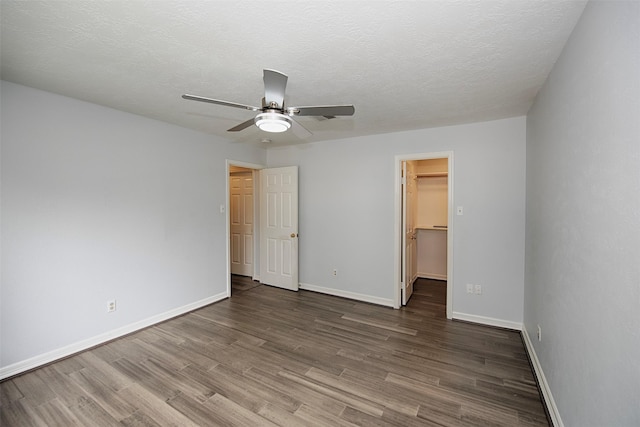 2030 Cutter Dr, League City, TX 77573 - unfurnished bedroom featuring wood finished floors, a spacious closet, baseboards, a closet, and a textured ceiling