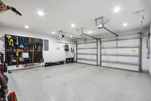 garage featuring a garage door opener, electric panel, and recessed lighting