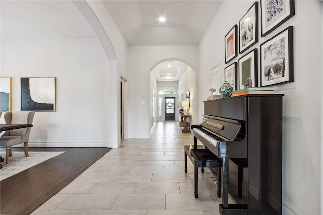 entryway with arched walkways, vaulted ceiling, recessed lighting, and light tile patterned flooring