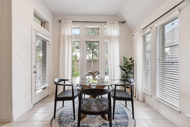 dining room with vaulted ceiling, light tile patterned flooring, and baseboards