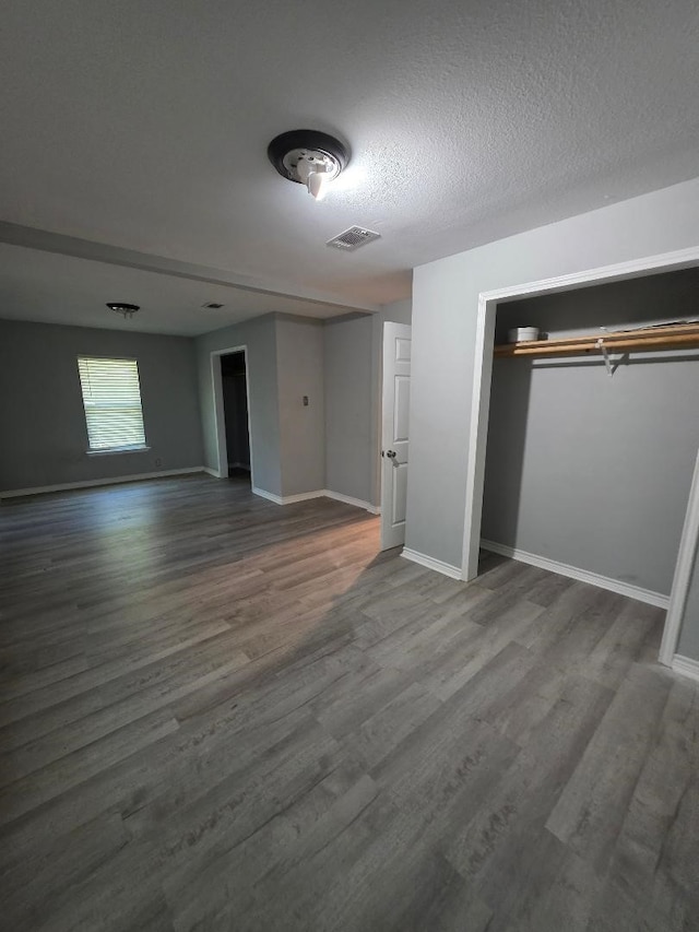 123 25th Ave N, Texas City, TX 77590 - unfurnished bedroom featuring wood finished floors, baseboards, a textured ceiling, and a closet