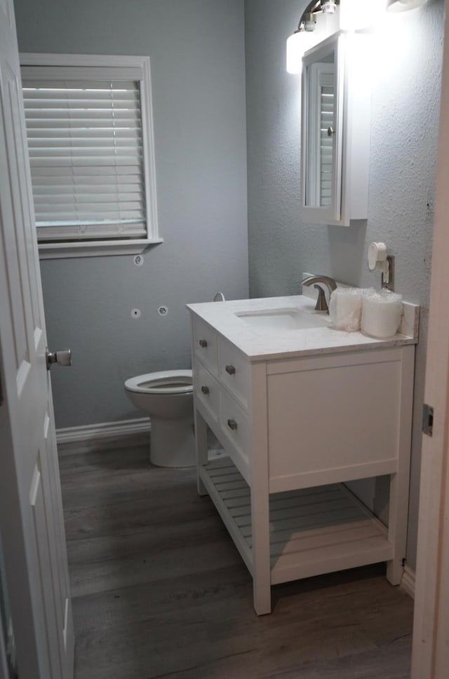123 25th Ave N, Texas City, TX 77590 - bathroom with vanity, wood finished floors, toilet, and baseboards