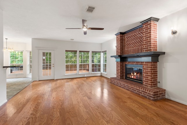 19906 Bayberry Creek Dr, Magnolia, TX 77355 - unfurnished living room featuring a ceiling fan, a fireplace, wood finished floors, and plenty of natural light
