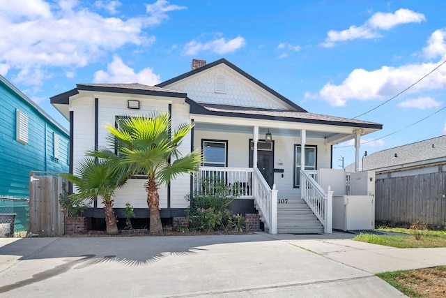 2107 54th St, Galveston, TX 77551 - shotgun-style home featuring a porch, fence, and a chimney