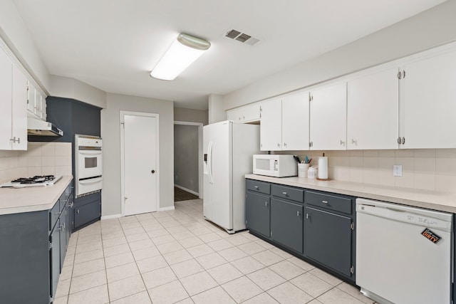 211 Cedar Ln, El Lago, TX 77586 - kitchen with white appliances, a warming drawer, backsplash, light countertops, and under cabinet range hood