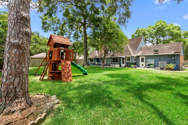 211 Cedar Ln, El Lago, TX 77586 - view of jungle gym featuring cooling unit and a lawn