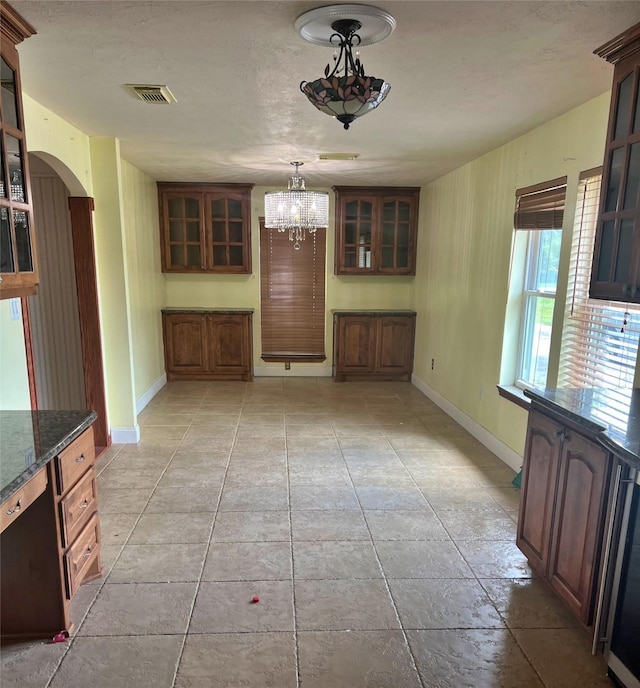3811 Empress Ln, Richmond, TX 77406 - unfurnished dining area featuring arched walkways, a chandelier, baseboards, and light tile patterned floors