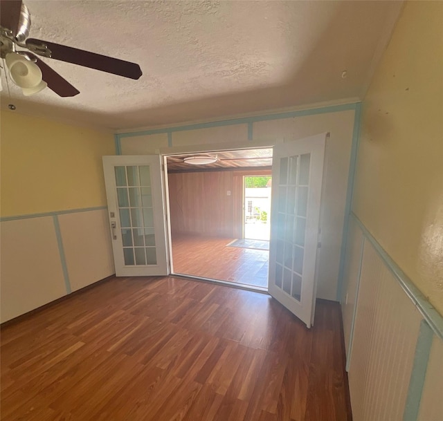 3811 Empress Ln, Richmond, TX 77406 - unfurnished room with wood finished floors, ceiling fan, a decorative wall, a textured ceiling, and a wainscoted wall