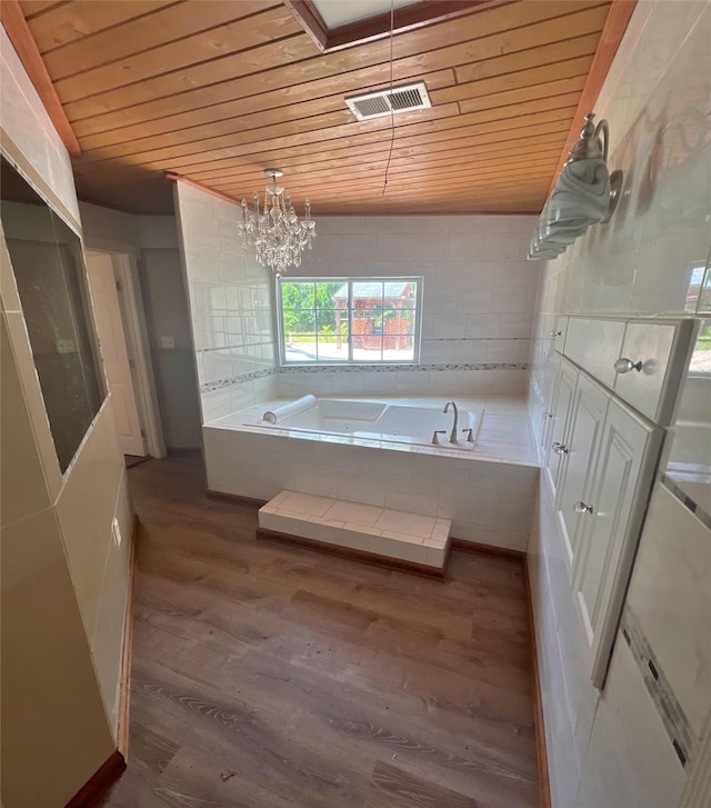 3811 Empress Ln, Richmond, TX 77406 - bathroom with wood ceiling, wood finished floors, a garden tub, and a chandelier