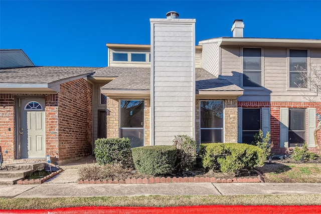 9393 Westwood Village Dr Unit 64, Houston, TX 77036 - view of front facade with a chimney, brick siding, and a shingled roof