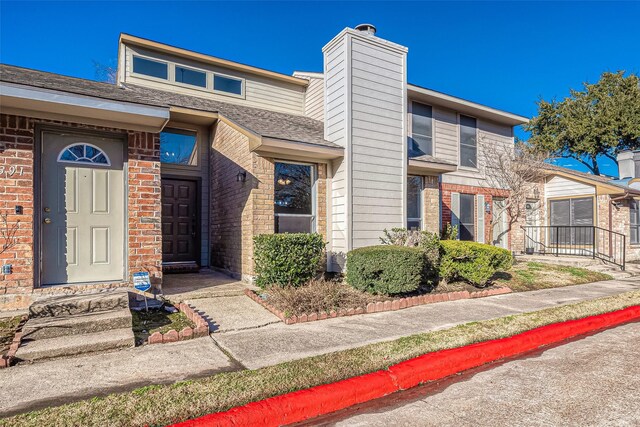9393 Westwood Village Dr Unit 64, Houston, TX 77036 - view of front facade with brick siding and a chimney