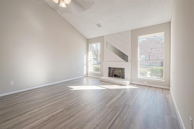 9393 Westwood Village Dr Unit 64, Houston, TX 77036 - unfurnished living room with wood finished floors, a textured ceiling, healthy amount of natural light, ceiling fan, and vaulted ceiling