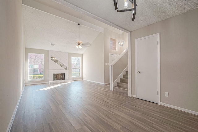 9393 Westwood Village Dr Unit 64, Houston, TX 77036 - unfurnished living room with a textured ceiling, a ceiling fan, stairs, wood finished floors, and baseboards