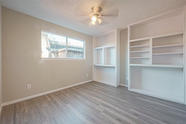 9393 Westwood Village Dr Unit 64, Houston, TX 77036 - unfurnished living room featuring a textured ceiling, wood finished floors, ceiling fan, and baseboards