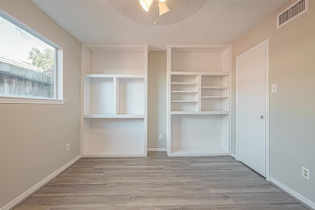 9393 Westwood Village Dr Unit 64, Houston, TX 77036 - unfurnished bedroom with a textured ceiling, wood finished floors, a closet, and baseboards