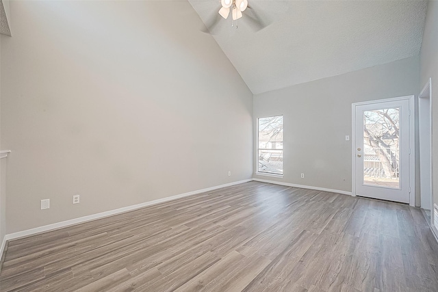 9393 Westwood Village Dr Unit 64, Houston, TX 77036 - spare room featuring a ceiling fan, wood finished floors, high vaulted ceiling, and baseboards