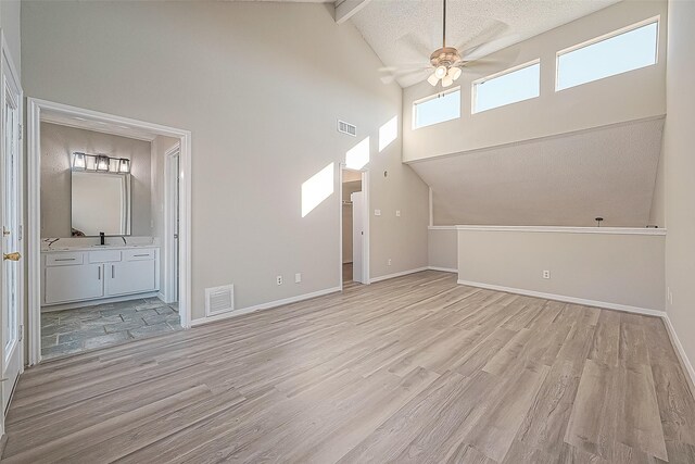 9393 Westwood Village Dr Unit 64, Houston, TX 77036 - unfurnished living room with high vaulted ceiling, a ceiling fan, light wood-style flooring, baseboards, and beam ceiling
