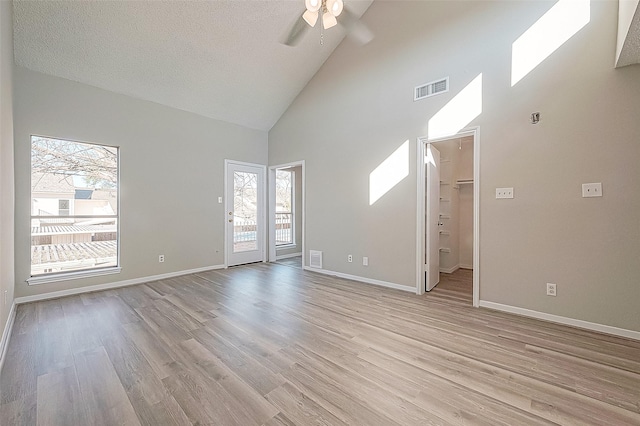 9393 Westwood Village Dr Unit 64, Houston, TX 77036 - unfurnished living room with high vaulted ceiling, ceiling fan, light wood-style floors, baseboards, and a textured ceiling