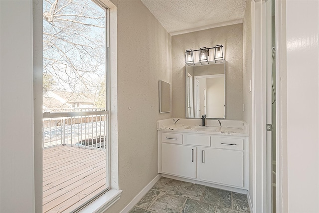 9393 Westwood Village Dr Unit 64, Houston, TX 77036 - bathroom with plenty of natural light, a textured wall, a textured ceiling, vanity, and baseboards