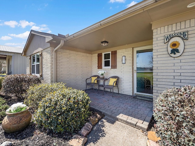 316 N Magnolia St, Highlands, TX 77562 - doorway to property featuring brick siding and covered porch