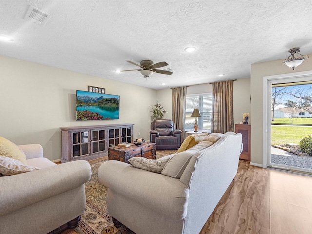 316 N Magnolia St, Highlands, TX 77562 - living area featuring light wood-style flooring, a ceiling fan, a textured ceiling, recessed lighting, and baseboards