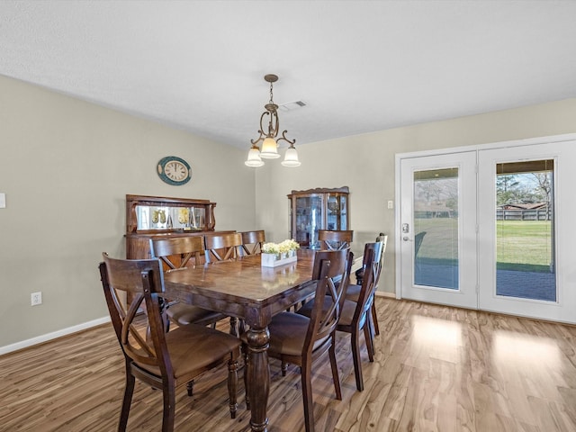 316 N Magnolia St, Highlands, TX 77562 - dining space with light wood-style flooring, baseboards, and a chandelier