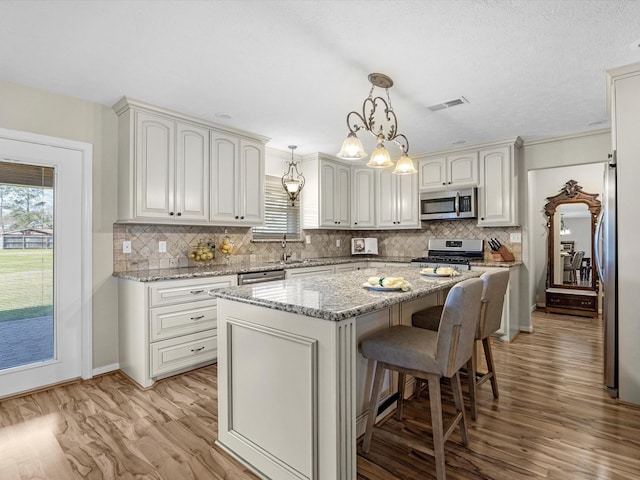 316 N Magnolia St, Highlands, TX 77562 - kitchen featuring appliances with stainless steel finishes, light wood finished floors, backsplash, and a sink