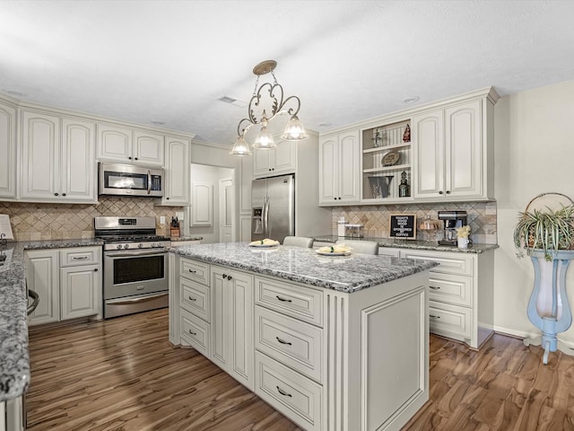 316 N Magnolia St, Highlands, TX 77562 - kitchen with appliances with stainless steel finishes, a center island, tasteful backsplash, and wood finished floors