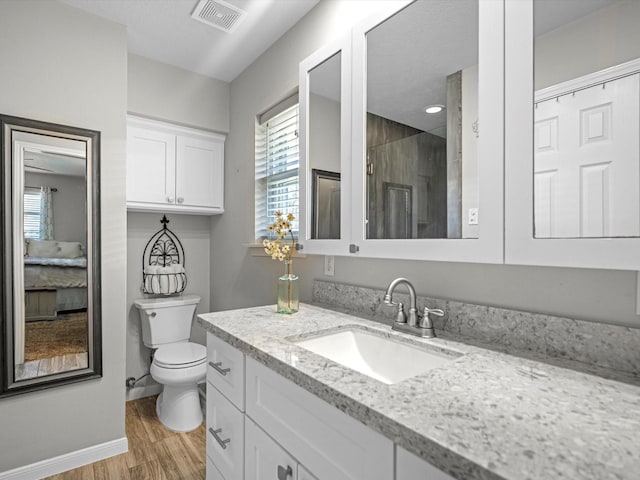316 N Magnolia St, Highlands, TX 77562 - full bath with toilet, vanity, wood finished floors, baseboards, and a shower stall