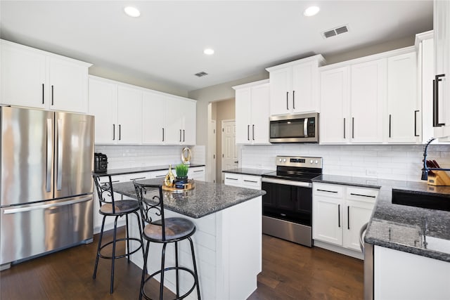 3804 Park Wood Dr, Corinth, TX 76208 - kitchen featuring appliances with stainless steel finishes, a sink, a center island, recessed lighting, and a kitchen breakfast bar