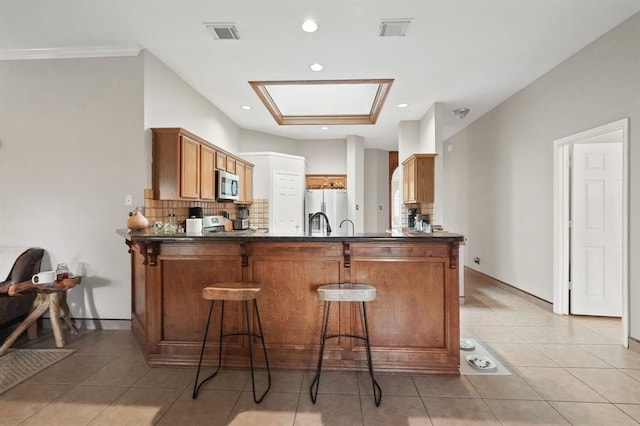 3522 Plymouth Pointe Ln, Missouri City, TX 77459 - kitchen featuring appliances with stainless steel finishes, decorative backsplash, a peninsula, dark countertops, and recessed lighting