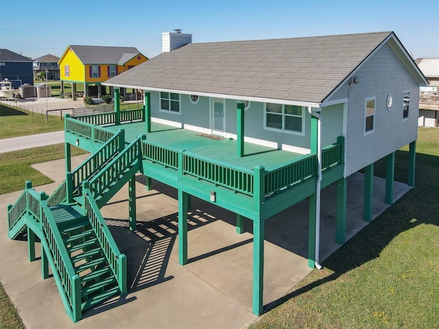 908 W Ln, Crystal Beach, TX 77650 - back of house with a chimney, a yard, a shingled roof, and stairway