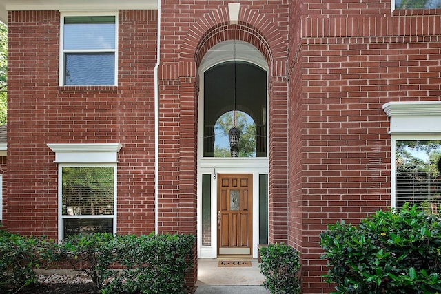 entrance to property featuring brick siding