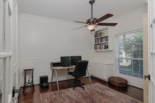 office featuring a decorative wall, dark wood-style flooring, ornamental molding, a ceiling fan, and a textured ceiling