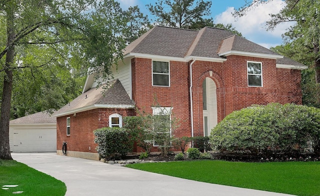 view of front of house with roof with shingles, brick siding, a garage, and a front yard